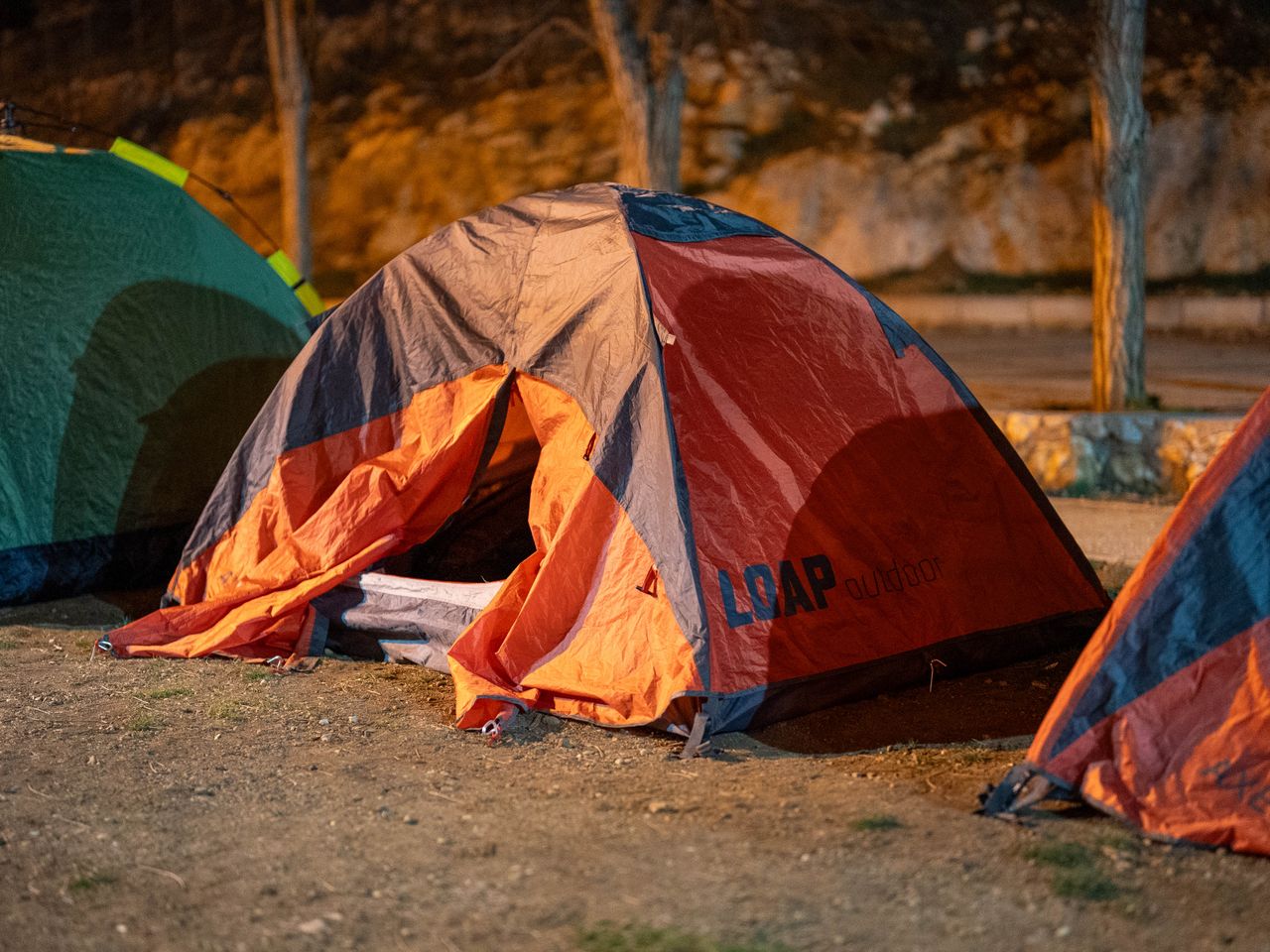 Orange and grey tent set up at a campsite under night skies in Tekir, Turkey.
